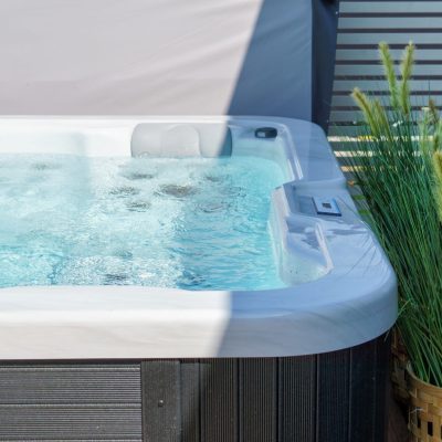 This image depicts an outdoor hot tub with a plant next to it.