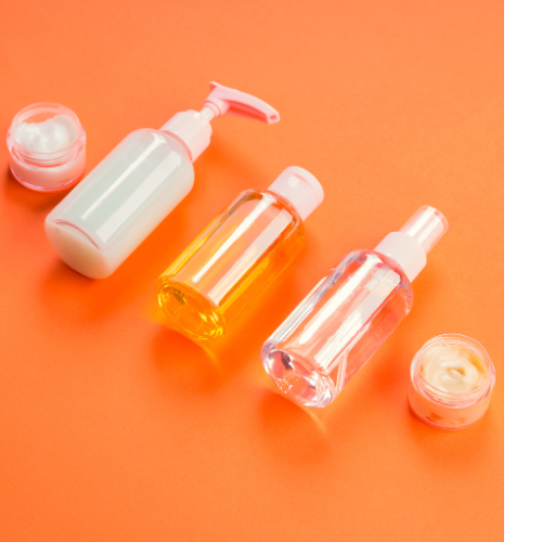 Various personal care products lay on an orange background