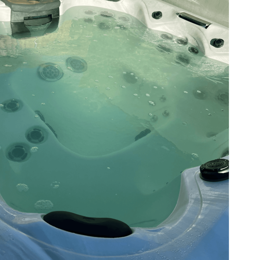 Overhead shot of an algae-infested hot tub. The water is green, cloudy and murky.