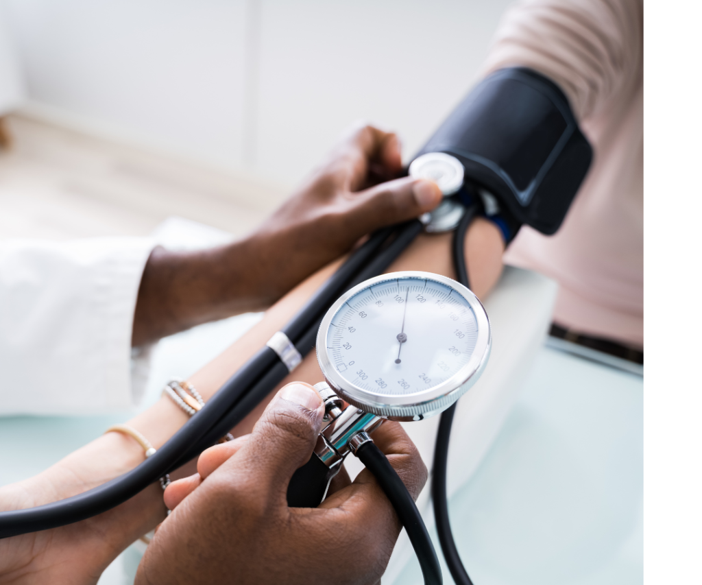 Image of a doctor in a white coat taking the blood pressure of a patient.