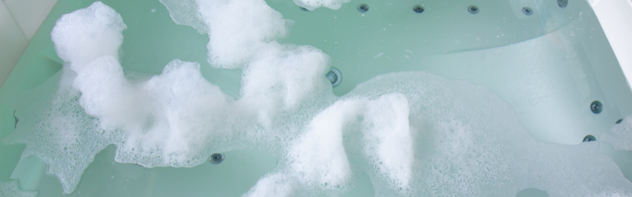 An overhead shot of a hot tub with foam on its water's surface