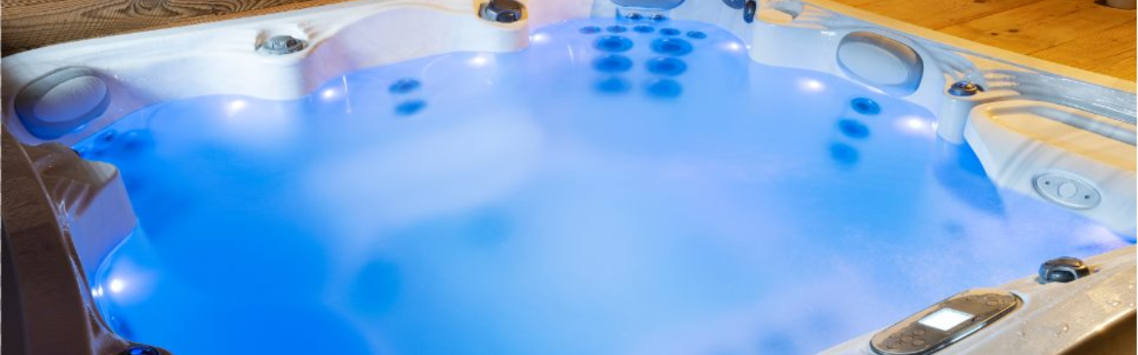 An overhead shot of a cloudy hot tub with its blue underwater lights on