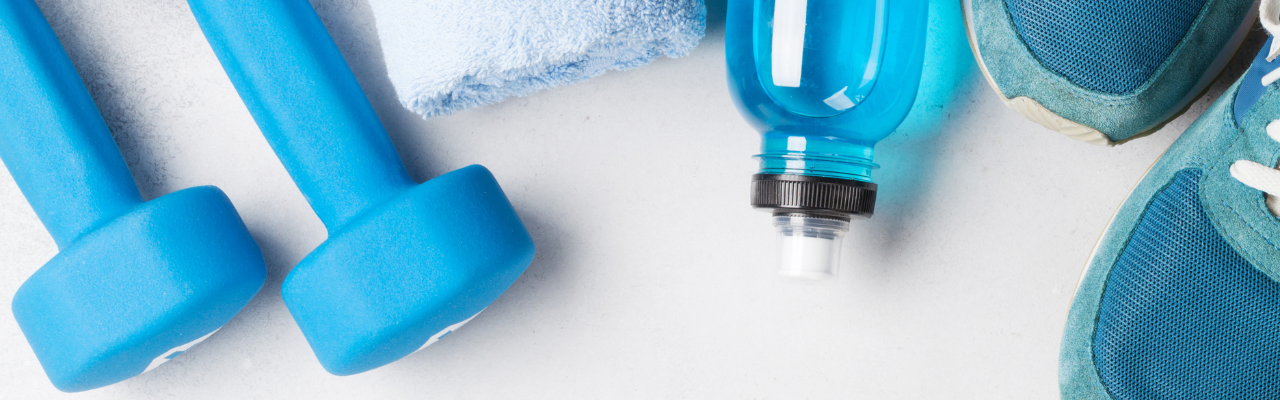 Overhead photo of 2 dumbbells, a water bottle and tennis shoes