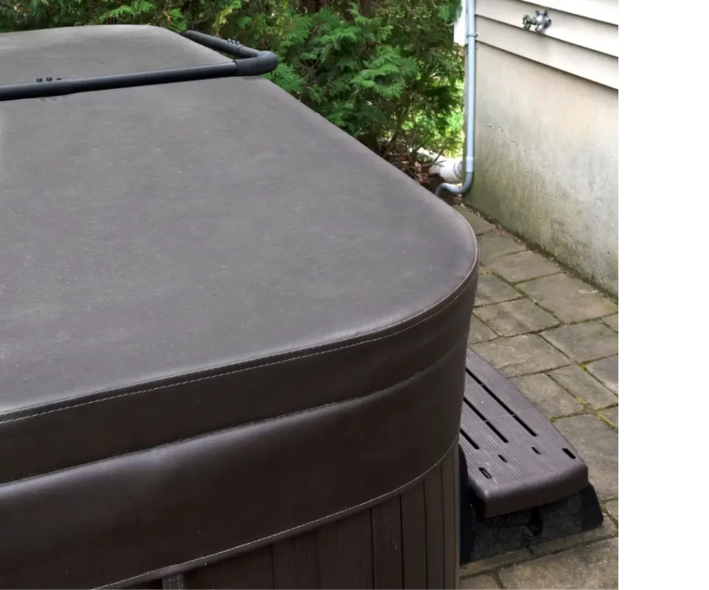 Tight camera shot of the corner of a hot tub with a brown cover on it